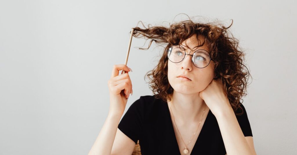 a woman that's playing with her hair using a pencil