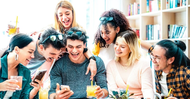 a group of friends happily looking at the phone