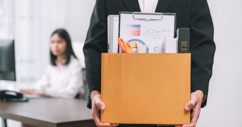 person quitting work and carrying a box full of his things