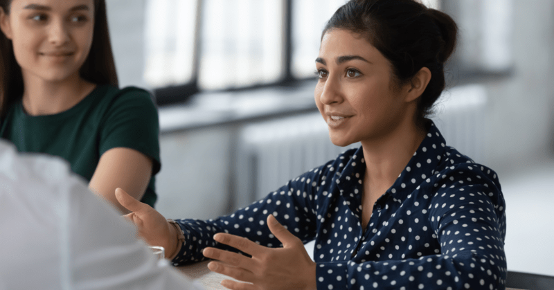 a woman being interviewed with another woman besides her listening