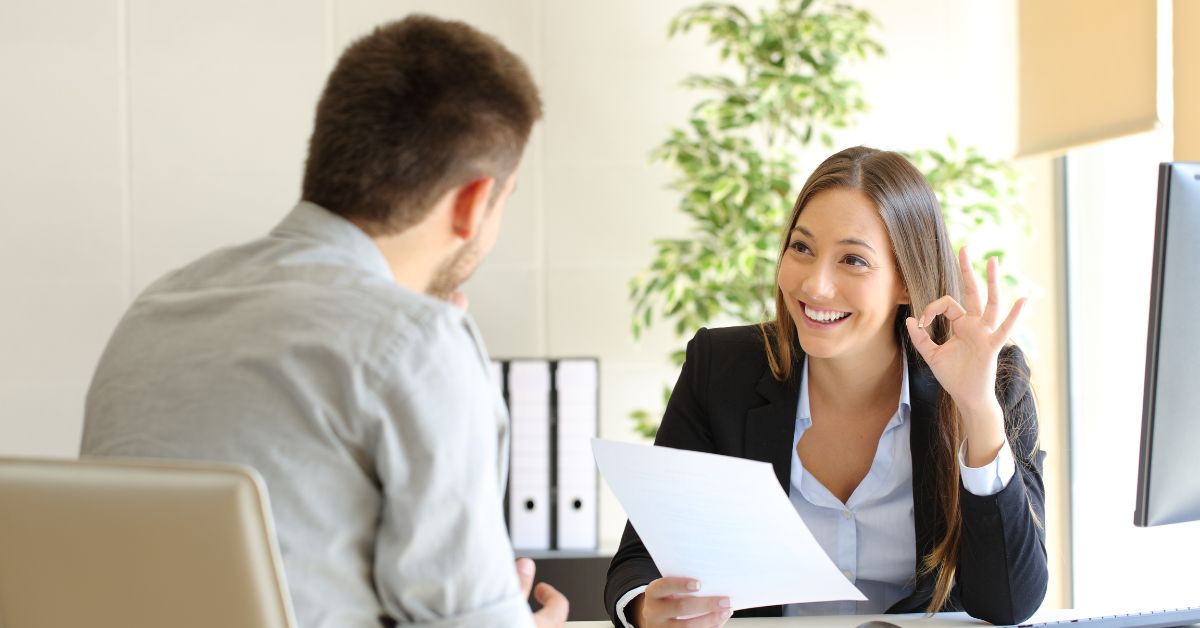 female interviewer giving an okay sign to a male interviewee