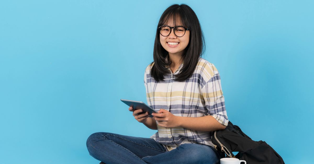 female student that's carrying books with a blue background